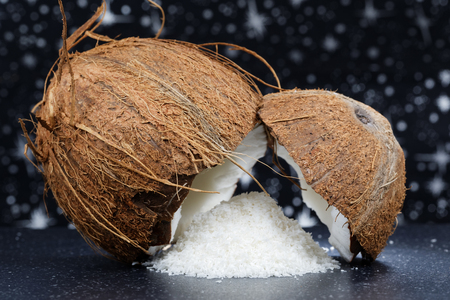 Fresh coconut and desiccated coconut on a stone tableの写真素材