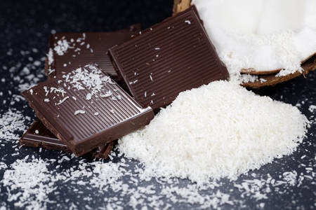 Dark chocolate and desiccated coconut on a old tableの写真素材