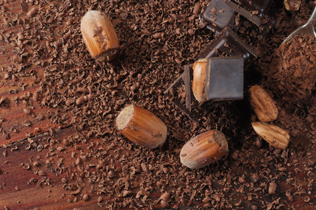 Dark chocolate and hazelnuts. Broken chocolate bar on black kitchen tableの写真素材