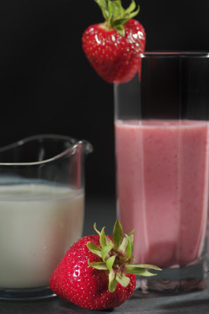 Traditional ayurvedic healthy drink with strawberries of yogurt and ice cube with drinkingの写真素材