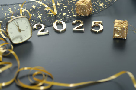 New Year's Eve celebration with clock and gift box on black backgroundの写真素材