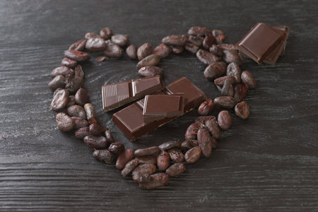 Chocolate and cocoa beans on a black wooden background, closeupの写真素材