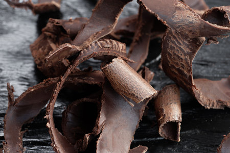 Chocolate shavings on black wooden table, close-upの写真素材
