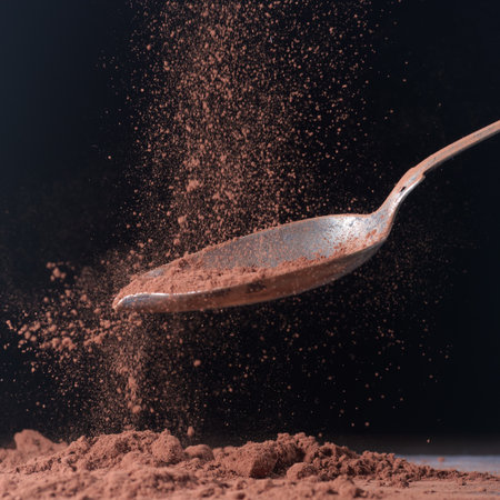 Spoon with cocoa powder on a black background, close-up