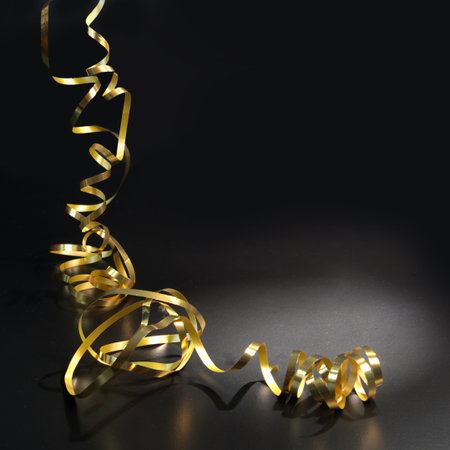 Golden serpentine on a black background. Festive decoration for the holiday.の写真素材