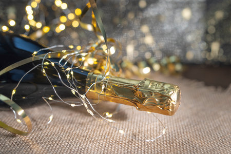 Bottle of champagne with garland on sackcloth background, close upの写真素材