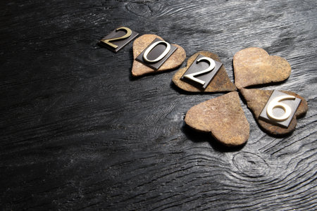 Happy New Year with heart shaped stone on black wooden background.の写真素材