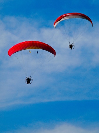 Paragliders flies in the blue skyの写真素材