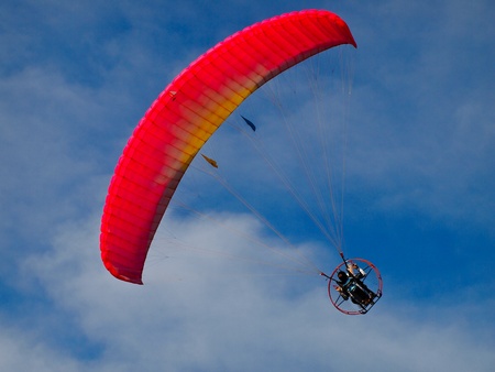 A Paraglider flies in the blue skyの写真素材