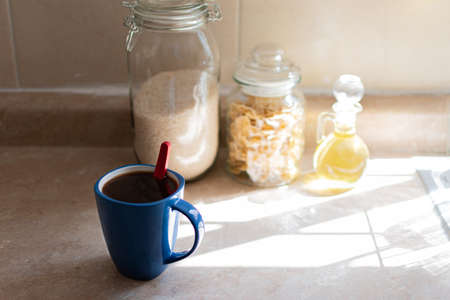 Blue cup of coffee in a kitchen in sunlight. Home concept.の写真素材