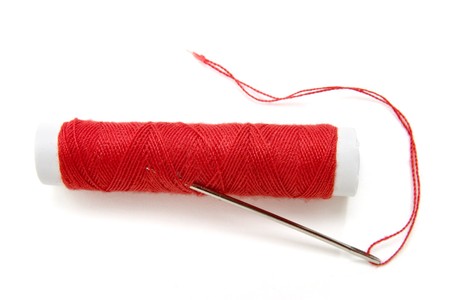red thread bobbin and needle on white background with pathの写真素材