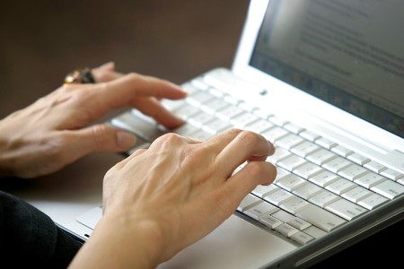 close up of woman hands typing on laptop