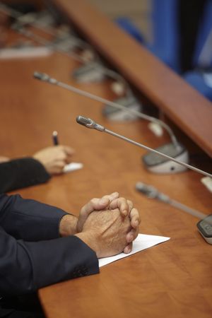 close up of conference meeting hands and microphones