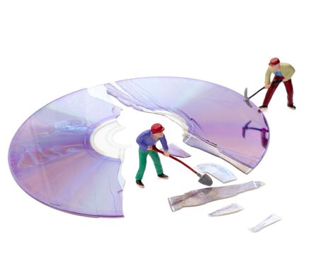 miniature toy workers repairing broken compact diskの写真素材