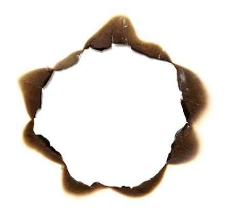 close up of burnt paper hole on white background の写真素材