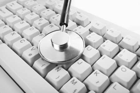 close up of desktop computer keyboard and a stethoscope