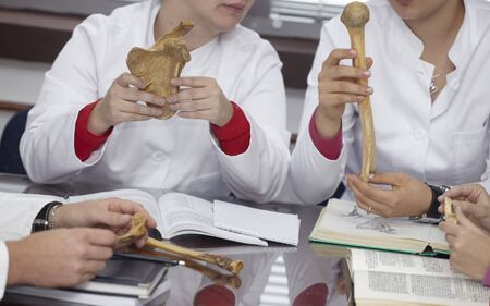 close up students holding a bone at biology class