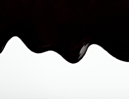 close up chocolate syrup leaking on white backgroundの写真素材
