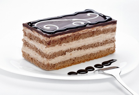 close up of a chocolate cream cake on white plateの写真素材