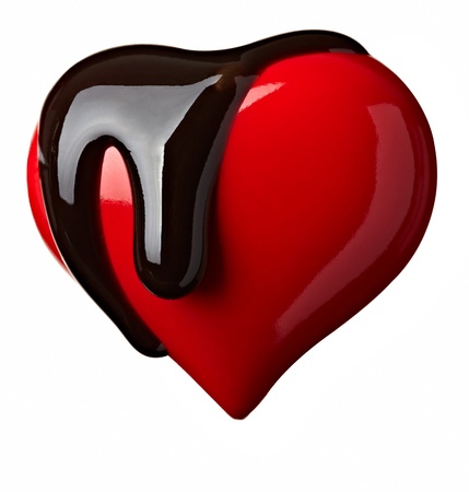 close up chocolate syrup leaking over heart shape symbol on white background の写真素材