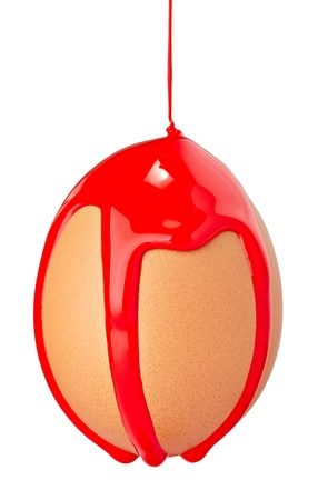 close up of an egg with leaking red paint on white background の写真素材
