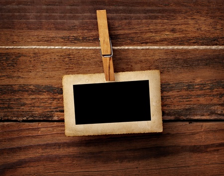 close up of an old photo and clothes peg on a wooden backgroundの写真素材