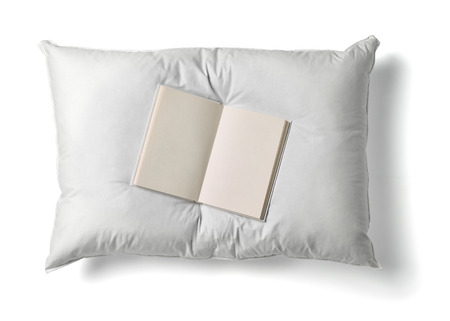 close up of  a white pillow and a book on white backgroundの写真素材