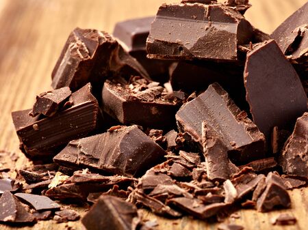 close up of chocolate pieces on  wooden background