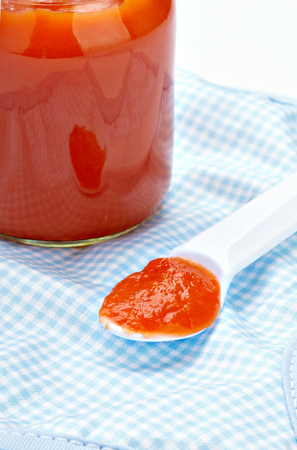 close up of baby food, poon abd bib on white background on white backgroundの写真素材