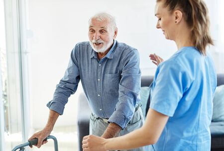 Doctor or nurse caregiver with senior man using walker assistanece  at home or nursing homeの写真素材