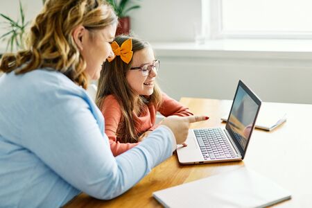 Mother and daughter Having fun with laptop at home