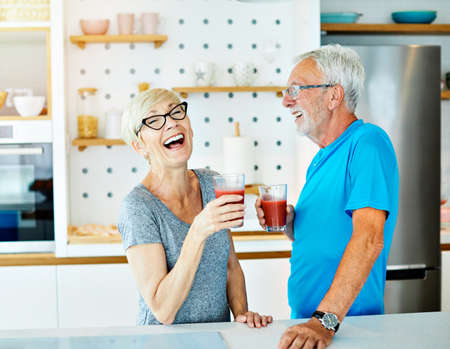 Happy senior couple enjoying breakfast nad healthy juice iafter the exercise  in the morning