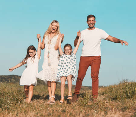 Portrait of a young happy family having fun outdoorsの写真素材