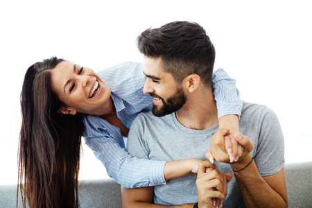 Portrait of a lovely young couple together on sofa at home