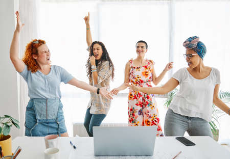 Happy young people friends dancing in the officeの写真素材