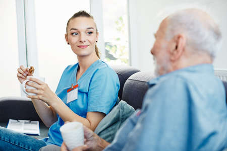 Doctor or nurse caregiver with senior man at home or nursing homeの写真素材