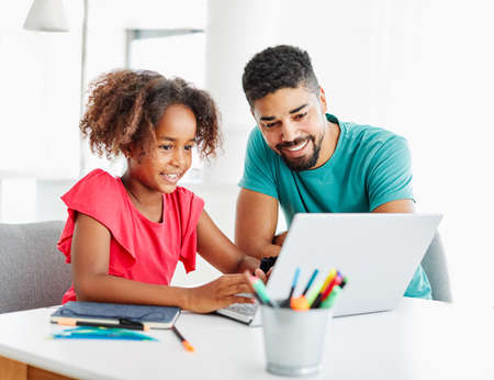 Father and daughter Having fun with laptop at home