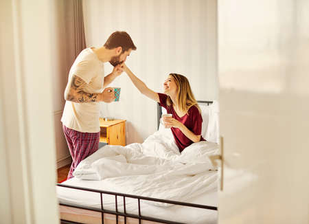 Portrait of a young happy couplewaking up in the bedroom in morningの写真素材