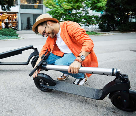 Young couple having fun driving electric scooter through the cityの写真素材