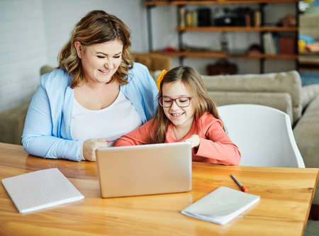 Mother and daughter Having fun with laptop at home