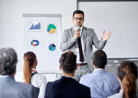 Senior busnessman writing and having a representation and speech by a whiteboard during a conference business meeting in an office. Business conceptの写真素材