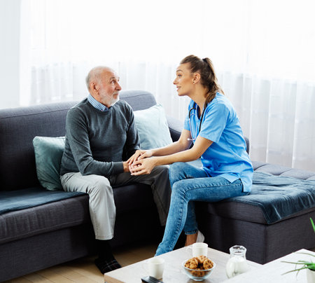 Doctor or nurse caregiver with sad lonely senior man at home or nursing homeの写真素材