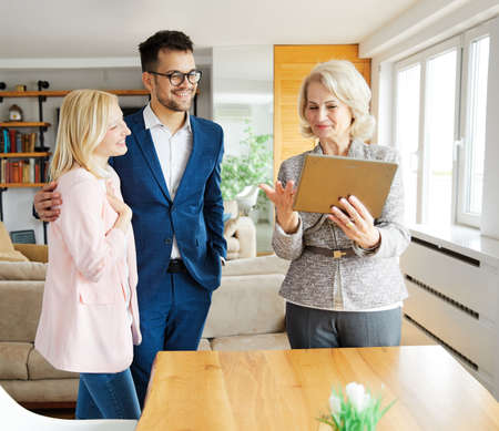 Young happy couple and an agent in a new propertyの写真素材