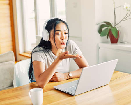 Portrait of a young beautiful woman having video call on laptop at home