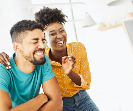 Portrait of a lovely young couple having fun and laughing together at homeの写真素材