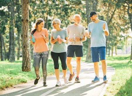 Smiling active senior people jogging together in the parkの写真素材