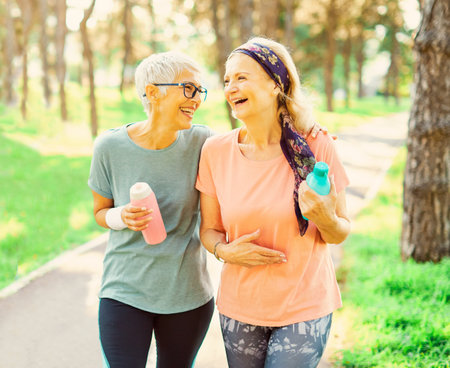 Smiling active senior women jogging together in the parkの写真素材