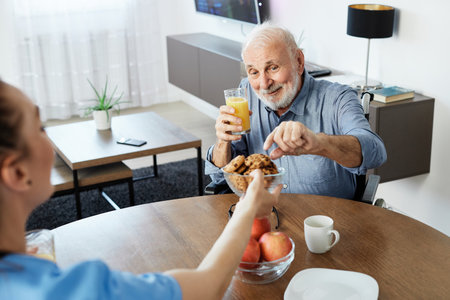 Doctor or nurse caregiver with senior man ina wheelchair at home or nursing homeの写真素材