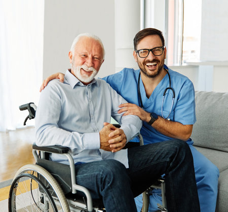 Doctor or nurse caregiver helping senior man in a wheelchair at home or nursing homeの写真素材