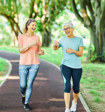 Smiling active senior people jogging together in the parkの写真素材